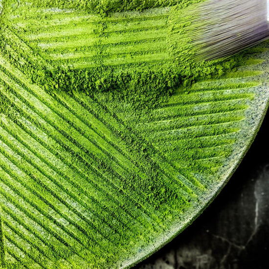 A shot of a brush brushing matcha from a matcha mill.